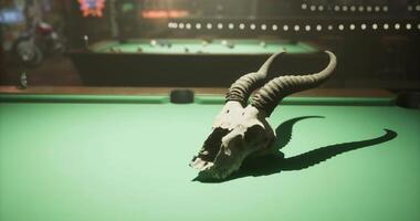 CGI Skull with horns resting on a pool table in a lively game venue video