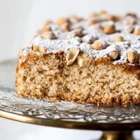 A piece of cake on a gold plate with nuts photo