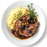 A plate of meat and mashed potatoes with a garnish of parsley photo