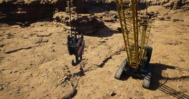 CGI Heavy construction crane working in a rocky desert landscape during daylight video