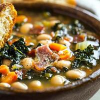 A bowl of soup with beans, kale, and bacon photo
