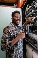 Technician organizes network equipment while smiling in data center during afternoon hours photo