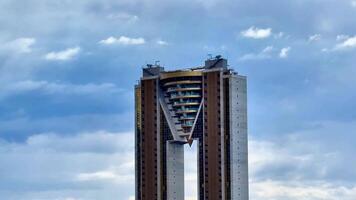 A striking and visually captivating building design featuring an innovative and unique shape set under a dramatic sky photo