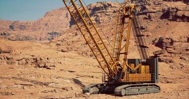 CGI Heavy construction crane operates in arid desert landscape for mining projects video