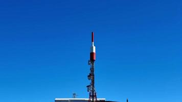 A large antenna tower with a red and white flag photo