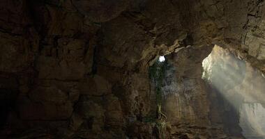 CGI Light streams through a cave opening revealing natural rock formations video