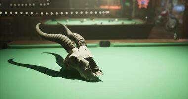 CGI Skull with horns displayed on a green billiards table in a dimly lit bar video