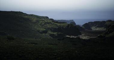 CGI Rolling green hills stretch towards the horizon, fading into a gray ocean video
