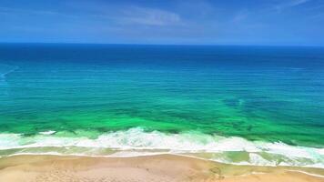A breathtaking aerial view showcasing the vibrant turquoise ocean waves gently lapping against the sandy shore photo
