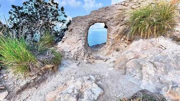 A hole in the rock on the edge of a cliff photo