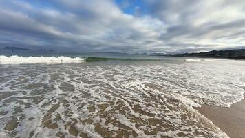 A tranquil beach scene with soft waves and a dramatic evening sky, ideal for relaxation and unwinding photo