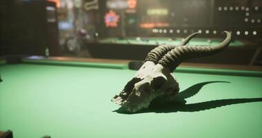 CGI Horned skull on a green billiards table at a lively game night video