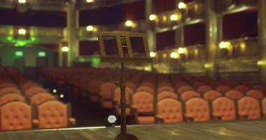 CGI Empty theater stage with a music stand awaiting a performance in the evening video