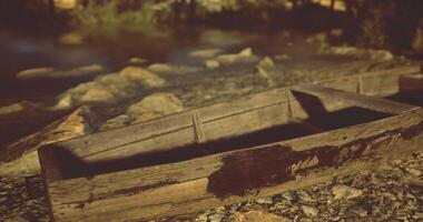 CGI Old wooden boat resting near the waters edge during sunset hours video