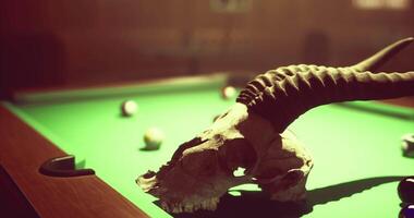 CGI Skull with horns placed on a green billiard table amid scattered balls video