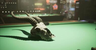 CGI Decorative skull on green billiard table in dimly lit bar atmosphere video