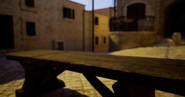 CGI Rustic wooden bench in quiet cobblestone alley at twilight video