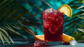 A vibrant glass of a chilled, refreshing drink rests on a table, surrounded by ice cubes and bright lemon slices. Tropical leaves in the background enhance the summer vibe. photo