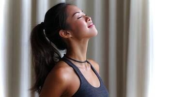 An Asian girl practices the camel pose in a serene indoor setting, exuding calmness and focus while enhancing her flexibility and strength during yoga. photo