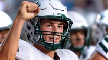 Player cheers with excitement, raising his helmet high after scoring a touchdown on the field at a local football game. Team members celebrate the moment together. photo