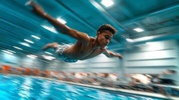 A boy of Latino descent performs an impressive forward flip off a springboard into a blue swimming pool during a competitive event. photo