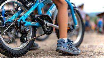 Latino boy pushes down on the chainring of his blue bicycle, showcasing motion and energy during a ride in a lively outdoor setting. photo
