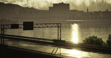 CGI Sunset over river reflects city skyline and empty highway video