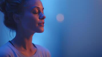 A woman is immersed in thought while engaging with artificial intelligence technology in a serene, blue-lit environment. The tranquil atmosphere enhances her focus on the podcasting experience. photo
