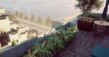 CGI Rooftop terrace with lush plants overlooking a serene waterway during sunset video