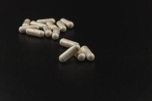 Pills scattered on a dark surface highlighting their texture photo
