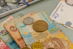 Ukrainian currency displayed on a table with banknotes and coins photo
