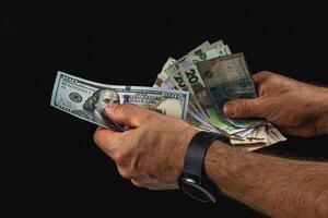 Currency exchange with various banknotes in hands photo