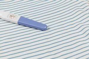 Pregnancy test on a striped fabric background photo