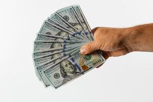 Person holding stack of hundred dollar bills in hand photo