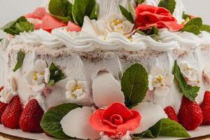 Intricate cake adorned with flowers and fruits for celebration photo