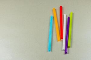 Colorful straws arranged on a light gray background photo