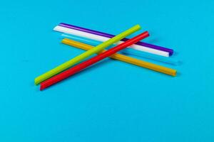 Colorful straws arranged on a vibrant blue surface photo