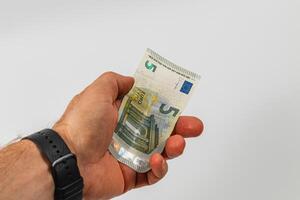 Someone holds a five euro note in their hand photo