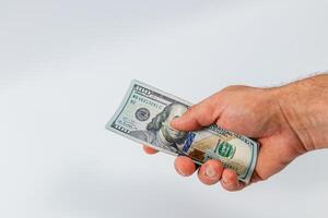 Hand holding a hundred dollar bill in clear focus photo
