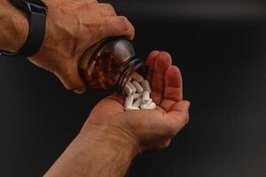 Pouring dietary supplements into a palm for consumption photo
