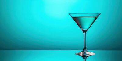 Elegant martini glass filled with clear liquid set against a vibrant teal background during a stylish cocktail gathering photo