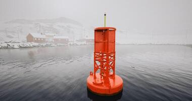 CGI Orange buoy floating in calm water surrounded by snow covered mountains video