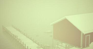 CGI Snowy dock with red cabin shrouded in winter mist at calm lake video
