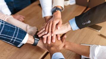 Teamwork. Top View Of United Business Team Holding Hands During Teambuilding Event Standing In Circle In Modern Office. High Angle View Shot. Selective Focus photo
