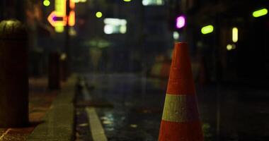 CGI Traffic cone illuminated by neon lights in a rainy urban setting at night video