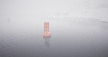 CGI Foggy morning view of a buoy in the water surrounded by mist and stillness video