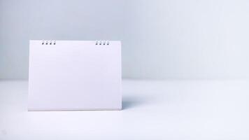 A blank white calendar on a clean surface, symbolizing fresh starts, future planning, scheduling, and key dates. Concepts of time management, productivity, and goal setting in any project or year. photo