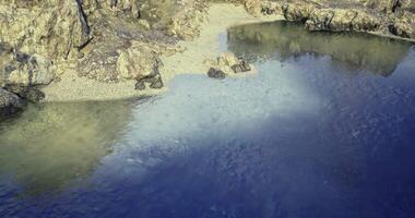 CGI Calm coastal view of rocky shore and clear water in sunlit setting video