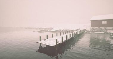 CGI Calm winter morning by the foggy lake with a wooden dock and cabin video