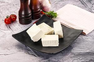 A black plate with cubes of cheese on it photo